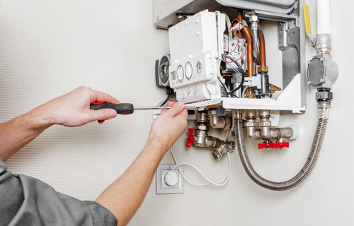 Artisan chauffagiste effectuant l’entretien annuel et le remplacement de chaudière