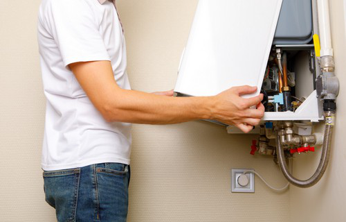 Artisan chauffagiste effectuant l’entretien annuel et le remplacement de chaudière